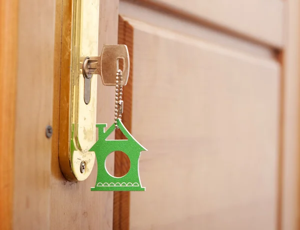 Символ дома и вставить ключ в замочную скважину — стоковое фото