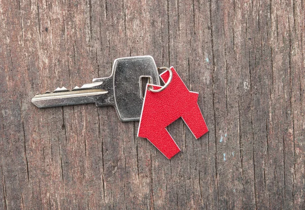 Evin ahşap antika arka plan üzerinde gümüş anahtar simgesi