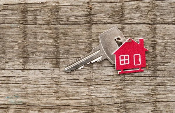 ヴィンテージの木製の背景に銀の鍵を家のシンボル — ストック写真