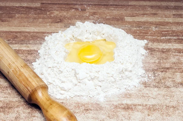 Broken egg on flour, means for making bread — Stock Photo, Image