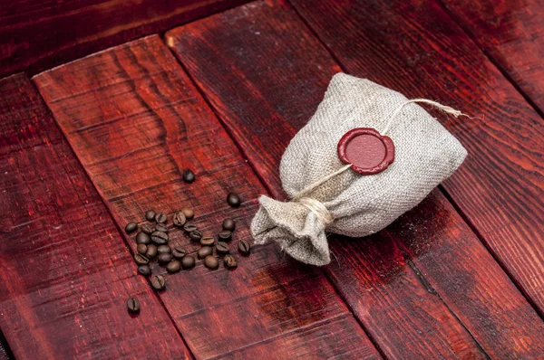 Old desk of coffee beans and sack — Stock Photo, Image