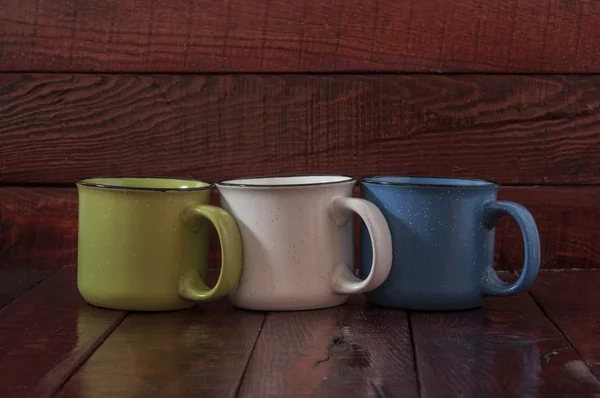 Tazas de colores sobre el fondo de madera —  Fotos de Stock