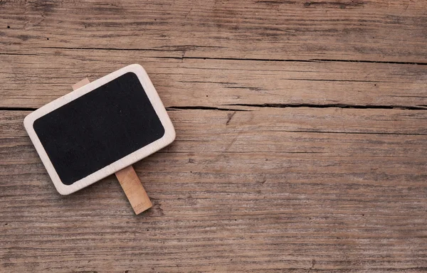 Small black chalkboard on wood background — Stock Photo, Image