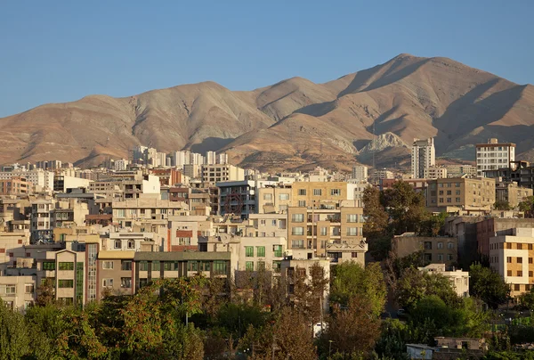 Skyline de edificios residenciales en frente de las montañas Brown y el cielo azul claro de Teherán — Foto de Stock