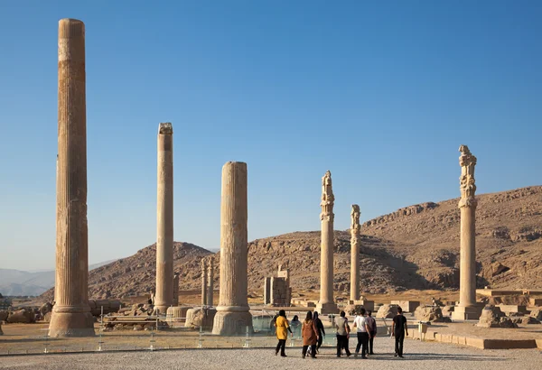 Ομάδα των ατόμων που επισκέπτονται τα ερείπια του παλατιού Apadana στον αρχαιολογικό χώρο Περσέπολις Σιράζ Φωτογραφία Αρχείου