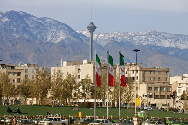 Staden i Teheran med Miladtornet och Iran flaggor i ramen — Stockfoto