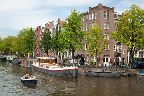 Группа людей, проходящих по Амстердамским каналам на лодке — стоковое фото