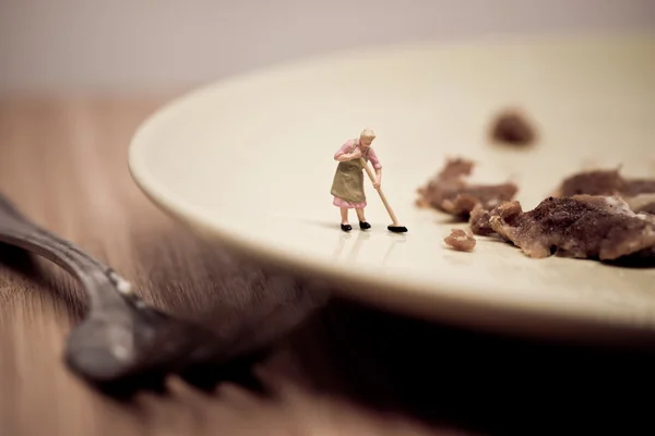 Miniature housewife washing dirty dish. Macro photo — Stock Photo, Image