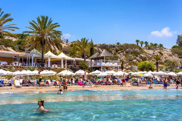 Paphos, Kypr - 24. července 2016: Lidé na dovolené na pláži Coral Bay, jedné z nejznámějších pláží na Kypru — Stock fotografie