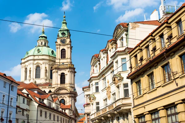 Szent Miklós templom emelkedik a szűk utcák között. Prága, Cseh Köztársaság. — Stock Fotó