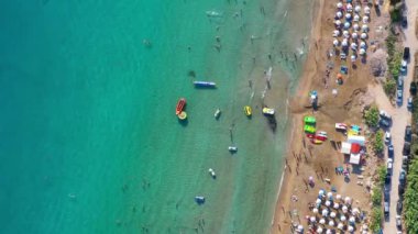 Turistler ve yerliler Coral Bay Sahili 'nde güzel bir yaz gününün tadını çıkarıyorlar. Paphos İlçesi, Kıbrıs