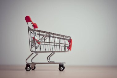 Masada minyatür alışveriş arabası var. Perakende ve alışveriş kavramı