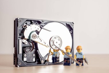 Billund, Danimarka - 15 Temmuz 2021: Teknisyenler HDD sürücüsünü tamir ediyor. İllüstrasyon Editörü