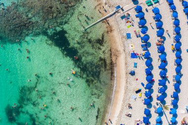 Kıbrıs 'taki Sandy Körfezi plajının yüzücüler ve güneşlenenlerle manzarası