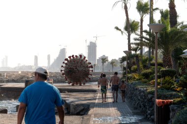 Şehir duvarındaki insanlar arasında bir virüs hücresi. Limasol, Kıbrıs