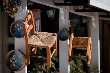 Geleneksel örülmüş sandalyeler ve dekore edilmiş elekler hediyelik eşya dükkanının girişinde.