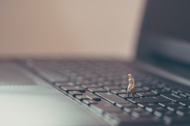 Dizüstü bilgisayarda yürüyüş minyatür işadamı