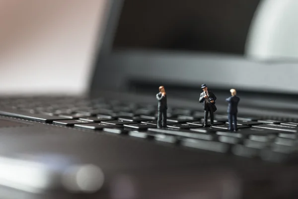 Des hommes d'affaires miniatures debout sur un clavier d'ordinateur portable — Photo