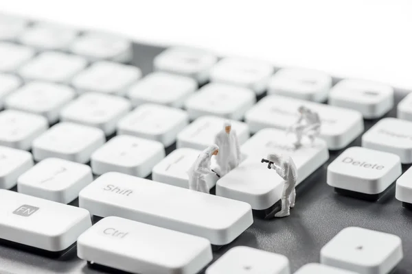 Grupo de criminalistas en miniatura inspeccionando el teclado de la computadora. Concepto de ciberdelincuencia — Foto de Stock