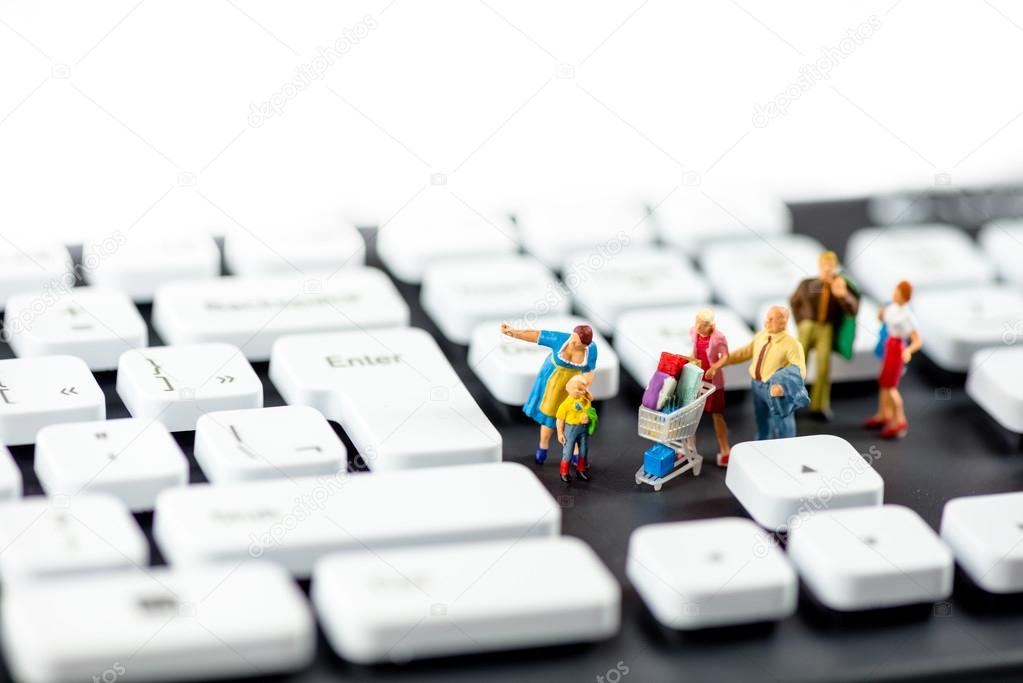 Friendly miniature family looking at computer keyboards. Technology concept