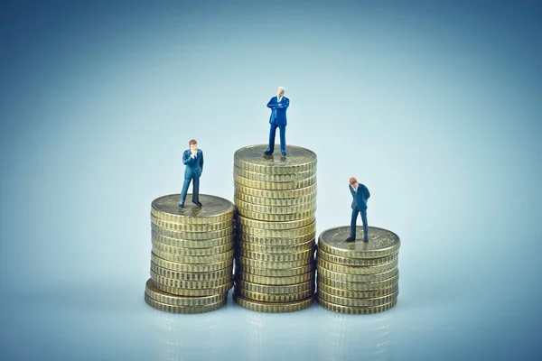 Concepto financiero. Gente de negocios de pie sobre pilas de monedas — Foto de Stock