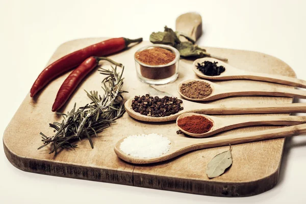 Various spices on kitchen spoons on grunge table — Stock Photo, Image