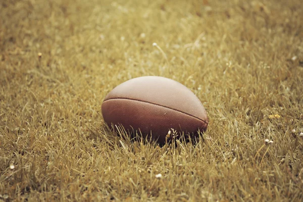 American Football lying on the field — Stock Photo, Image