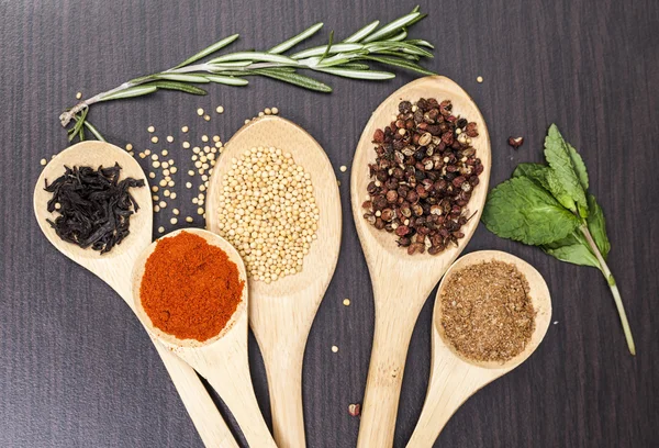 Colorful spices and wooden cutlery — Stock Photo, Image