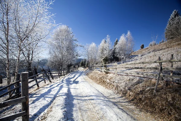 Strada sterrata invernale in cima alle colline — Foto Stock