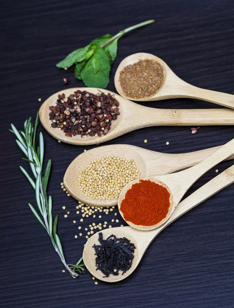 Spices on wooden spoons — Stock Photo, Image