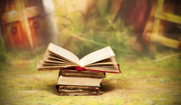 Pile of old books in front of fairy background