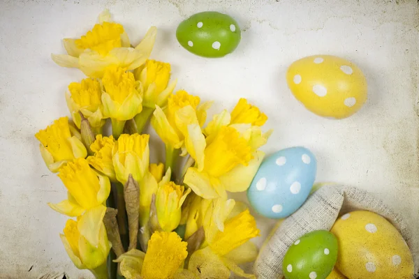 Pasen achtergrondkleur uit beschilderde eieren en gele bloemen — Stockfoto