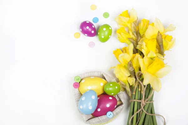 Ovos de Páscoa e um buquê de narcisos amarelos — Fotografia de Stock