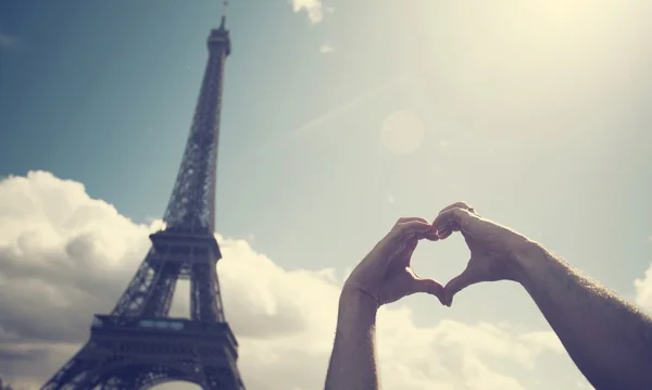 El amor en París: manos formando una forma de corazón frente al Eiff — Foto de Stock