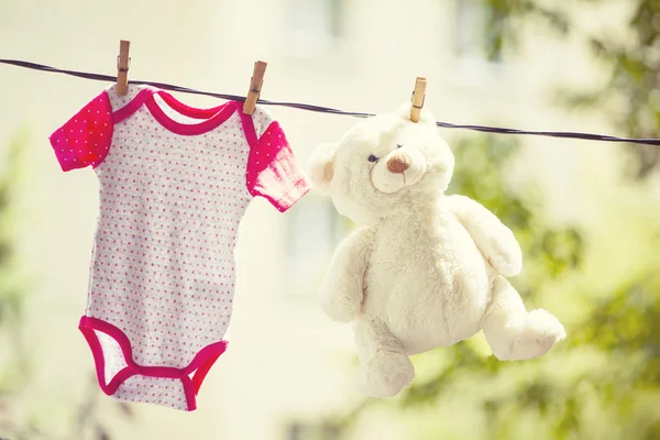 Babykleidung und Teddybär hängen an der Wäscheleine — Stockfoto
