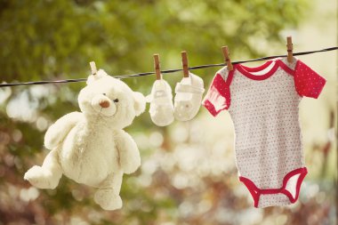 Bebek Giyim ve oyuncak ayı clothesline üzerinde asılı