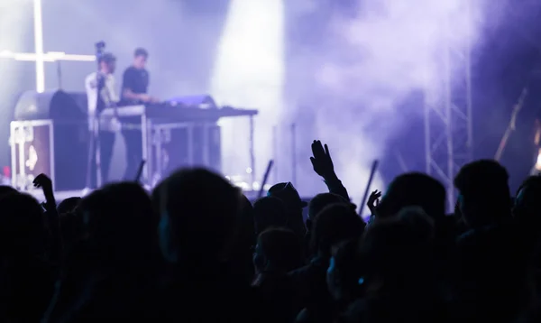 Animando a la multitud frente a las luces del escenario —  Fotos de Stock