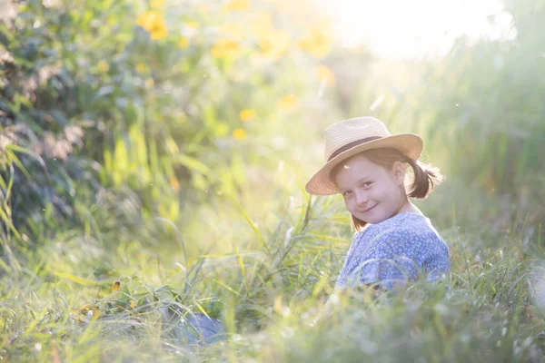 Little Adorable Dziewczyna Siedzi Kolorowe Pole Kwiatów Korzystających Jesienią Światło — Zdjęcie stockowe