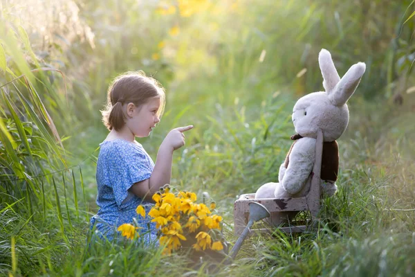 小女孩在草地上教她的泰迪熊室外学习概念 — 图库照片