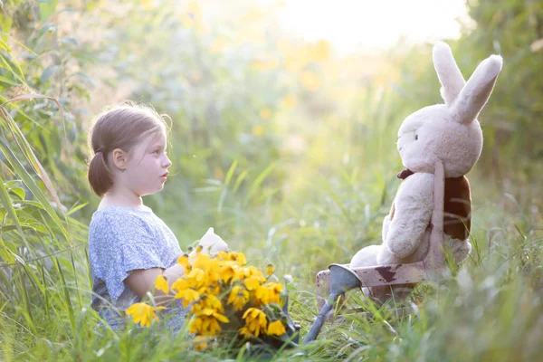 小女孩在草地上教她的泰迪熊室外学习概念 — 图库照片