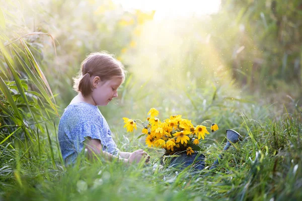 小女孩坐在秋天的田野里 浇满了秋天的花朵 — 图库照片