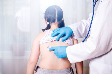 Çocuk doktoru klinikteki küçük kızı muayene ediyor. Çocuk tıbbi bakım konsepti.