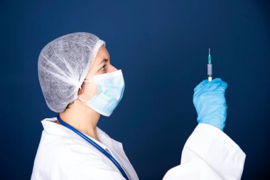 COVID-19 - Coronavirus hastalığı - 2019-nCoV, WUHAN Corona virüsü. Şırıngalı doktor iğneye hazırlanıyor..