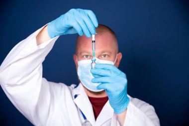 COVID-19 - Coronavirus hastalığı - 2019-nCoV, WUHAN Corona virüsü. Şırıngalı doktor iğneye hazırlanıyor..