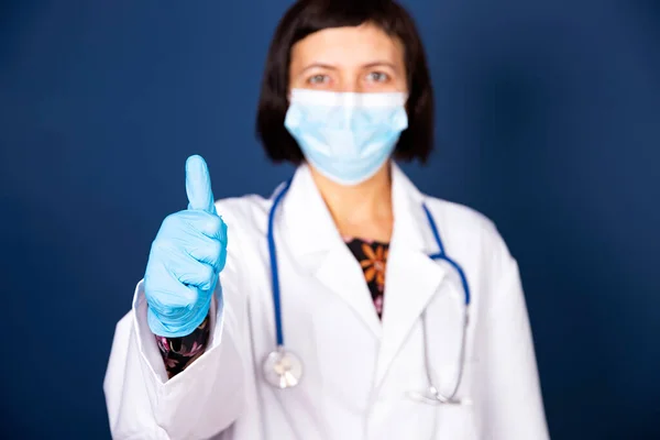 Усміхнена Жінка Лікар Стетоскопом Медичній Масці Показує Знак Ізольовано Синьому — стокове фото