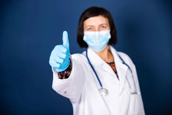 Усміхнена Жінка Лікар Стетоскопом Медичній Масці Показує Знак Ізольовано Синьому — стокове фото