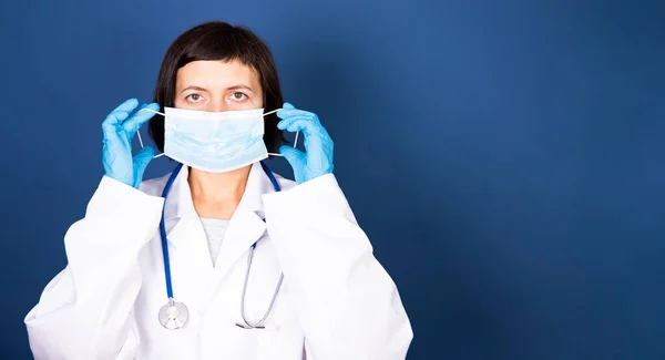 Retrato Uma Jovem Médica Enfermeira Colocando Máscara Estéril Fundo Azul — Fotografia de Stock