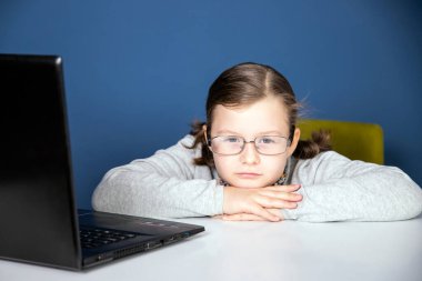 Uzaktan öğrenme çevrimiçi eğitim. Liseli kız çevrimiçi eğitim dersleri izliyor ve okul ödevi yapıyor. COVID-19 salgını çocukları çevrimiçi öğrenmeye zorluyor.