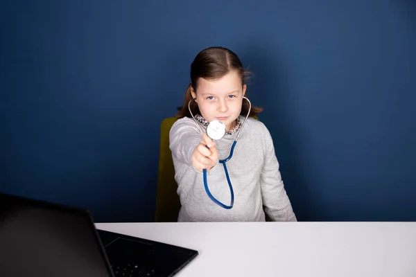 Little girl playing doctor with stethoscope.