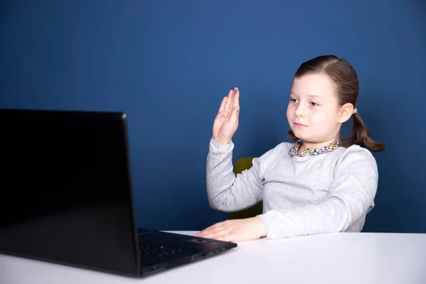 Distance learning-online education. School girl watching online education classes and doing school homework. COVID-19 pandemic forces children online learning.